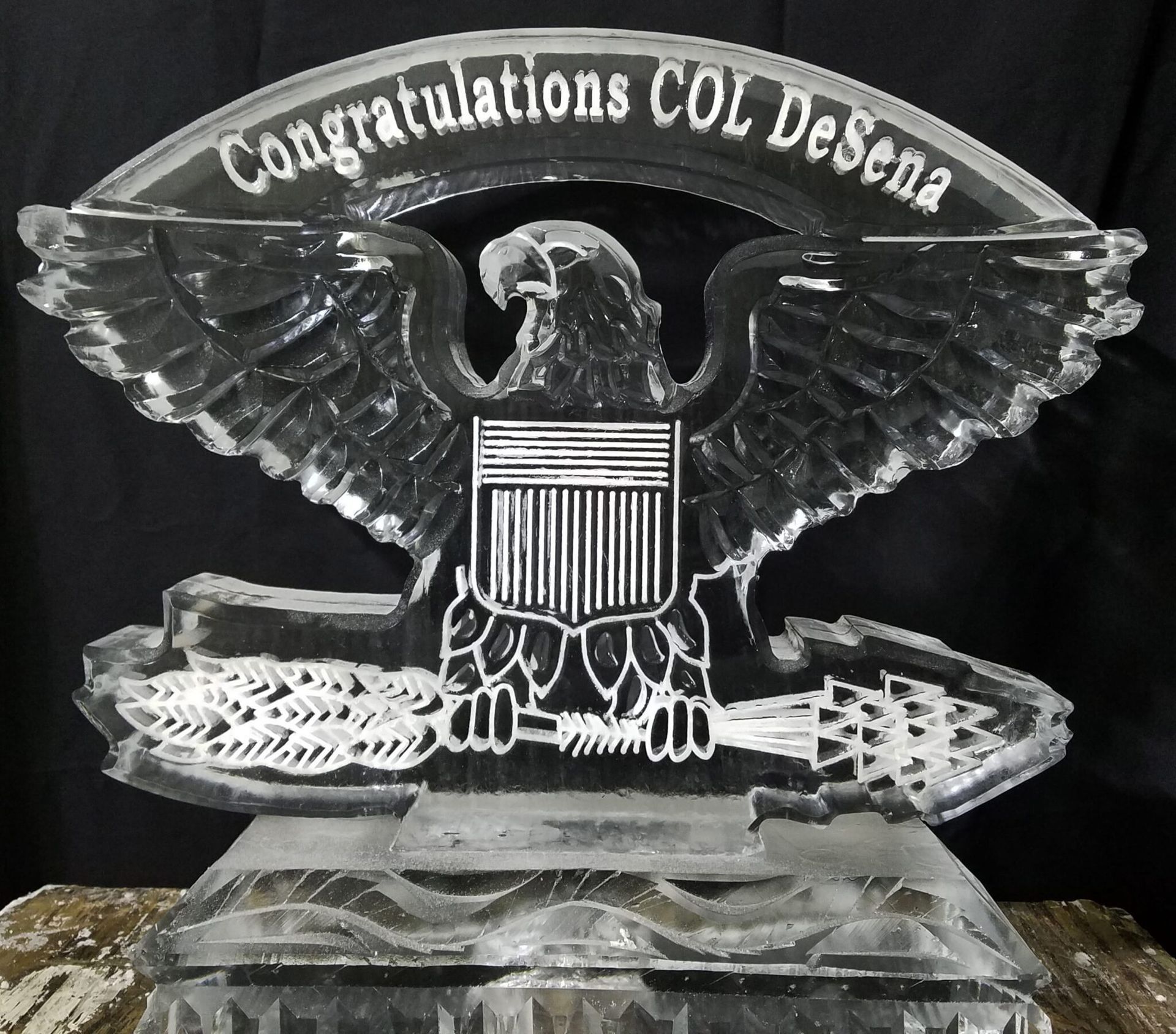Clear crystal eagle plaque reading “Congratulations COL Dosha” on a dark background