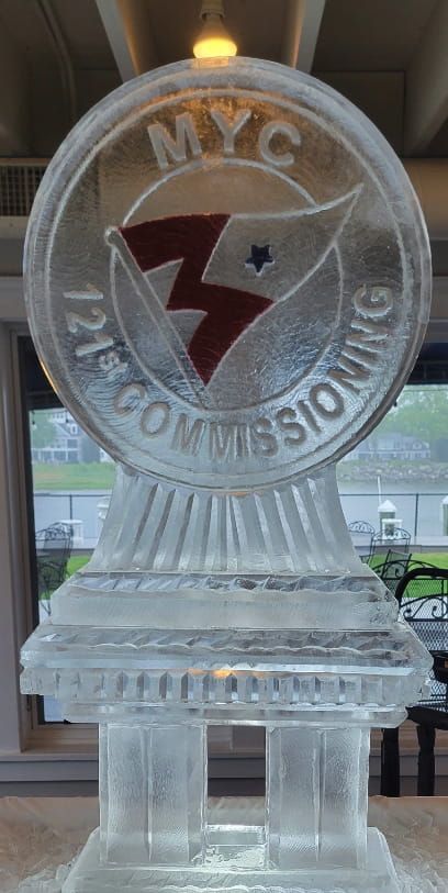 Clear glass award with NYC logo and NYC Commission text on a pedestal indoors