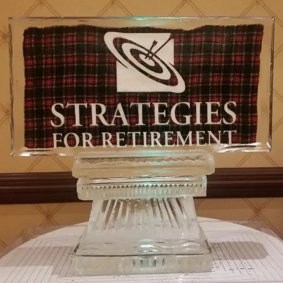 Plaid plaque reading “STRATEGIES FOR RETIREMENT” on a clear glass stand
