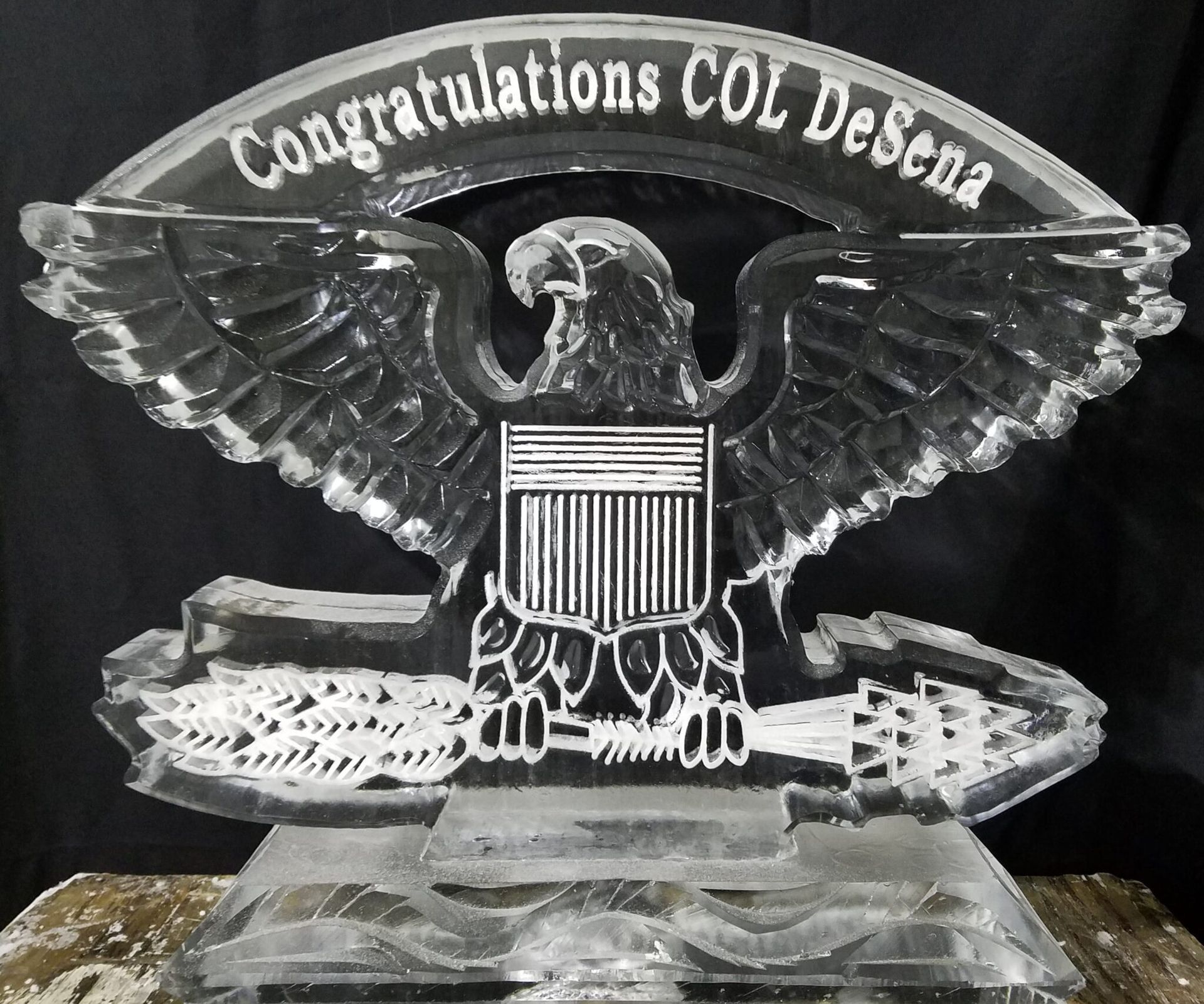 Clear crystal eagle plaque with “Congratulations COL DeSena” engraved on top.