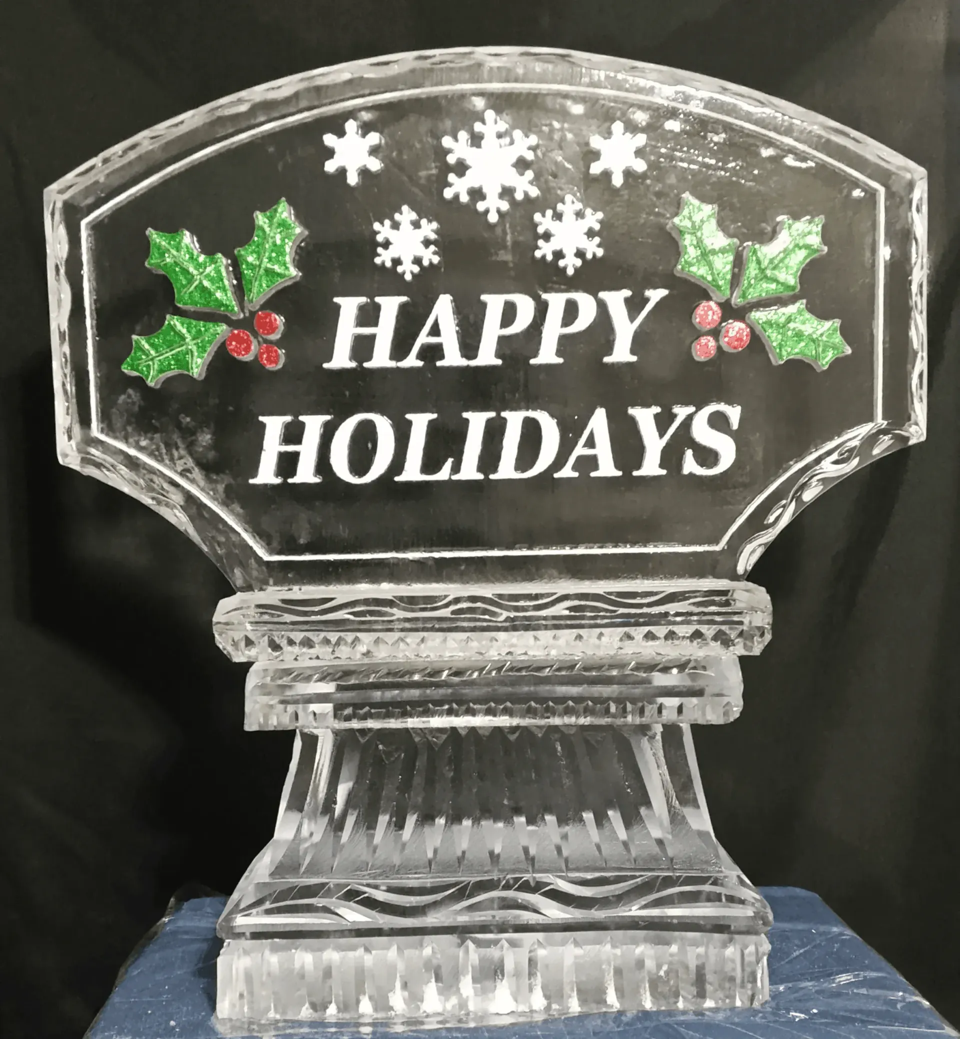 Clear acrylic holiday sign with holly and snowflakes reading “HAPPY HOLIDAYS”