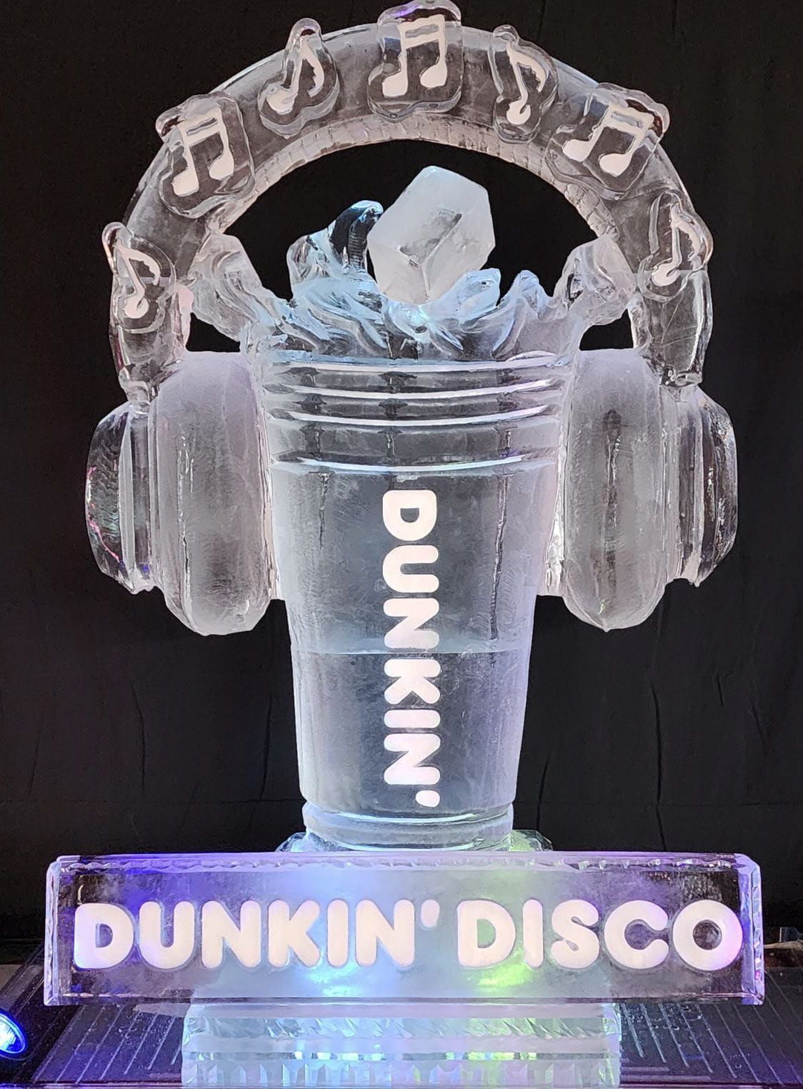 Neon Dunkin' cup with headphones and disco lights on a black background, labeled “DUNKIN' DISCO”