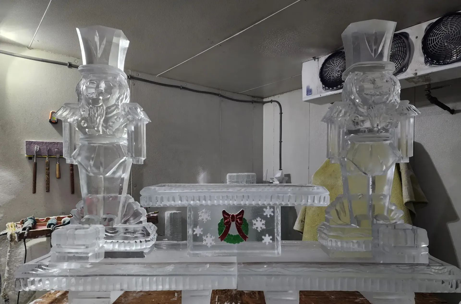 Two clear glass sculptures on a white shelf with a frosted decorative box in between.