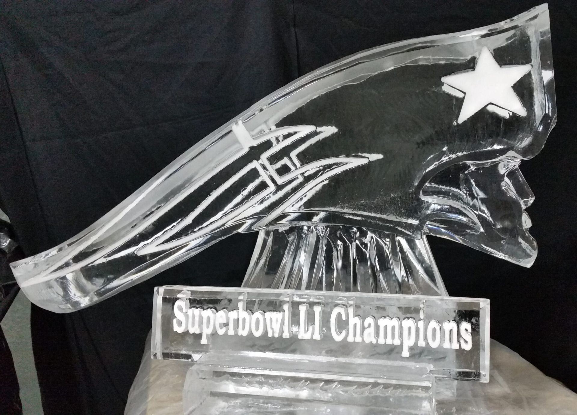 New England Patriots glass trophy reading “Superbowl LI Champions” with a star logo