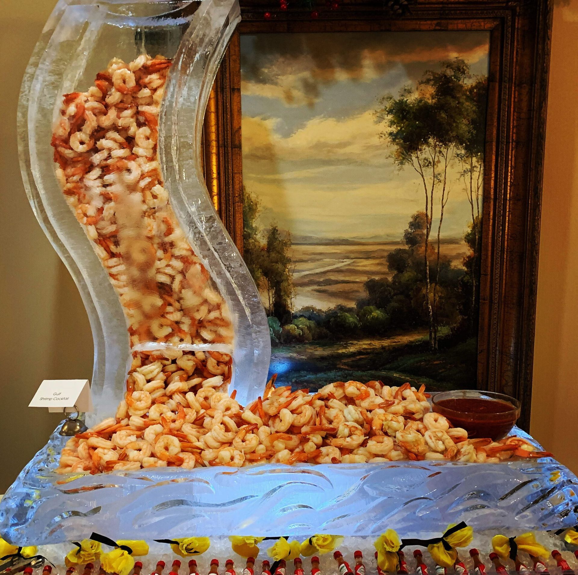 Pasta flowing from a wavy metal chute into a tray beside a framed landscape painting