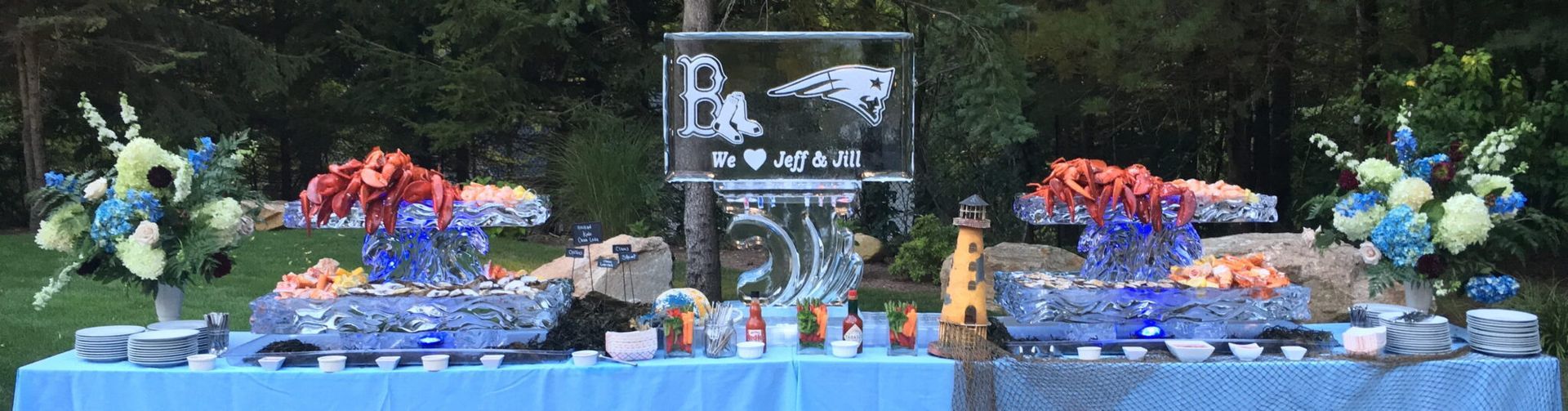 Blue buffet table with colorful desserts, flowers, and a chalkboard sign at a formal event