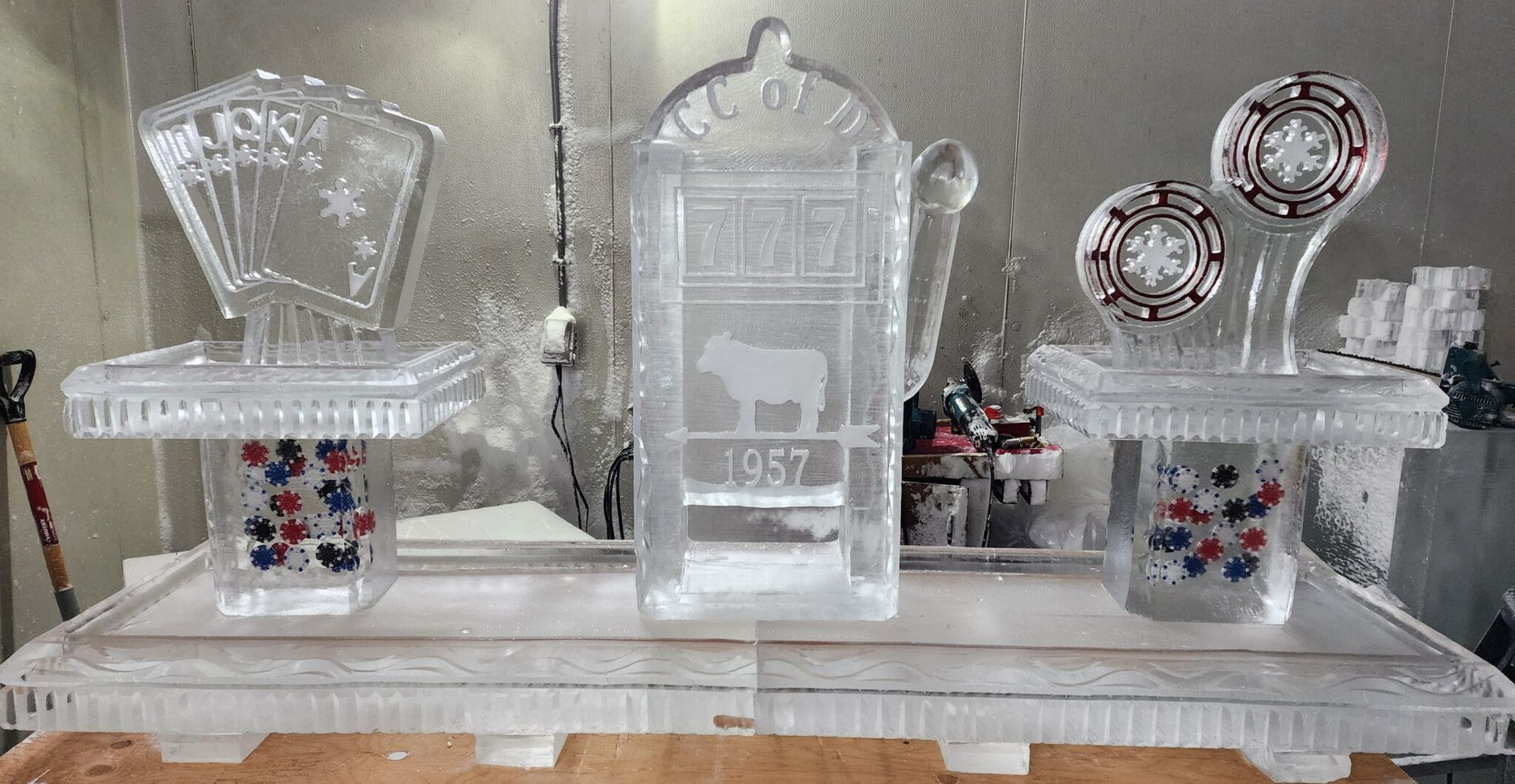 Clear acrylic candy display with two side trays of colorful sweets and a central pedestal labeled “357” on a white table.