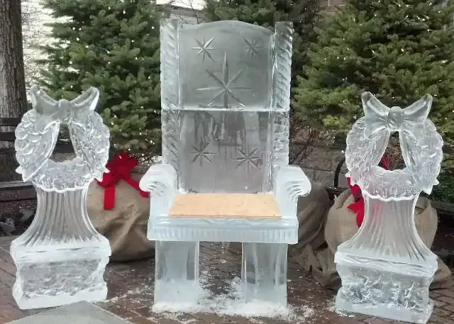 Crystal throne flanked by two frosted crystal cat statues on a wooden floor outdoors