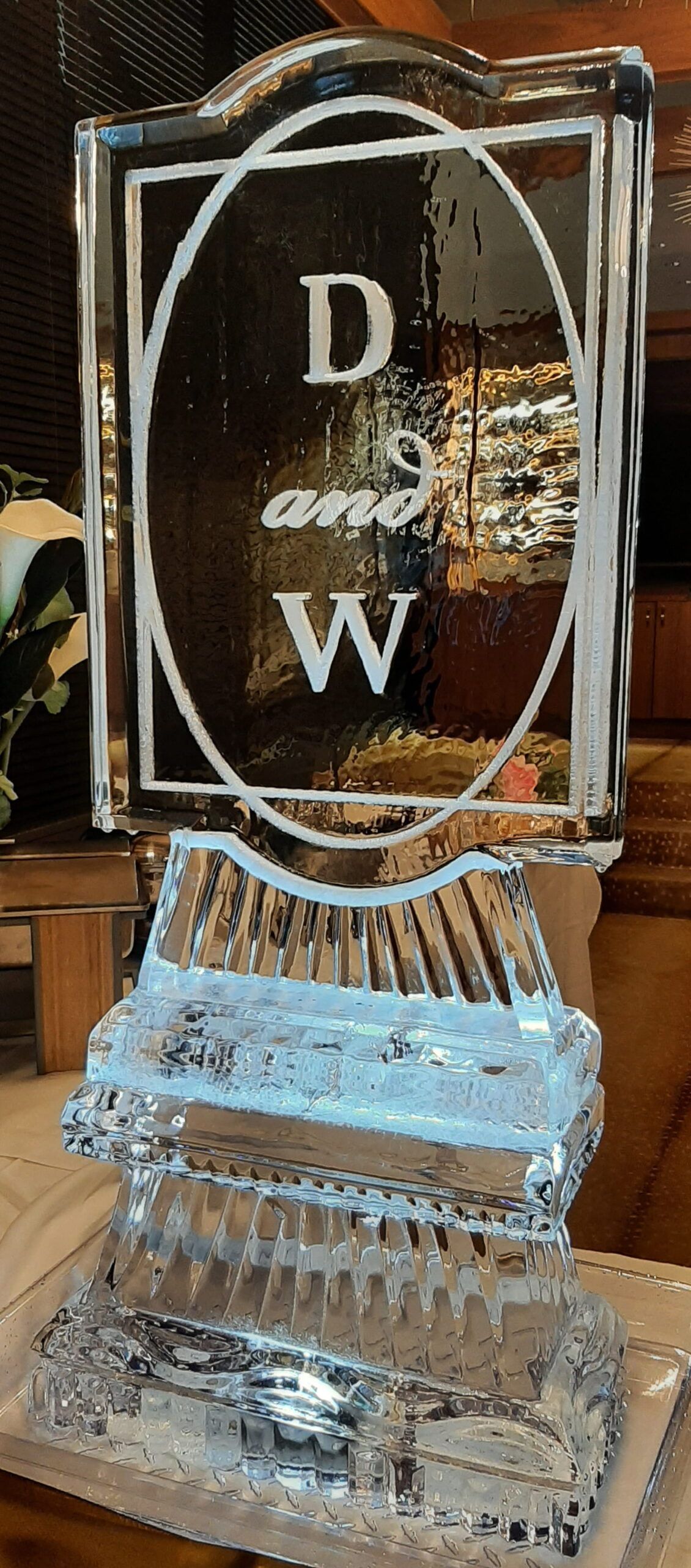 Clear glass trophy with “D W” engraved on a black plaque