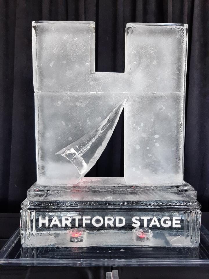 Transparent glass trophy on a black base labeled “HARTFORD STAGE”