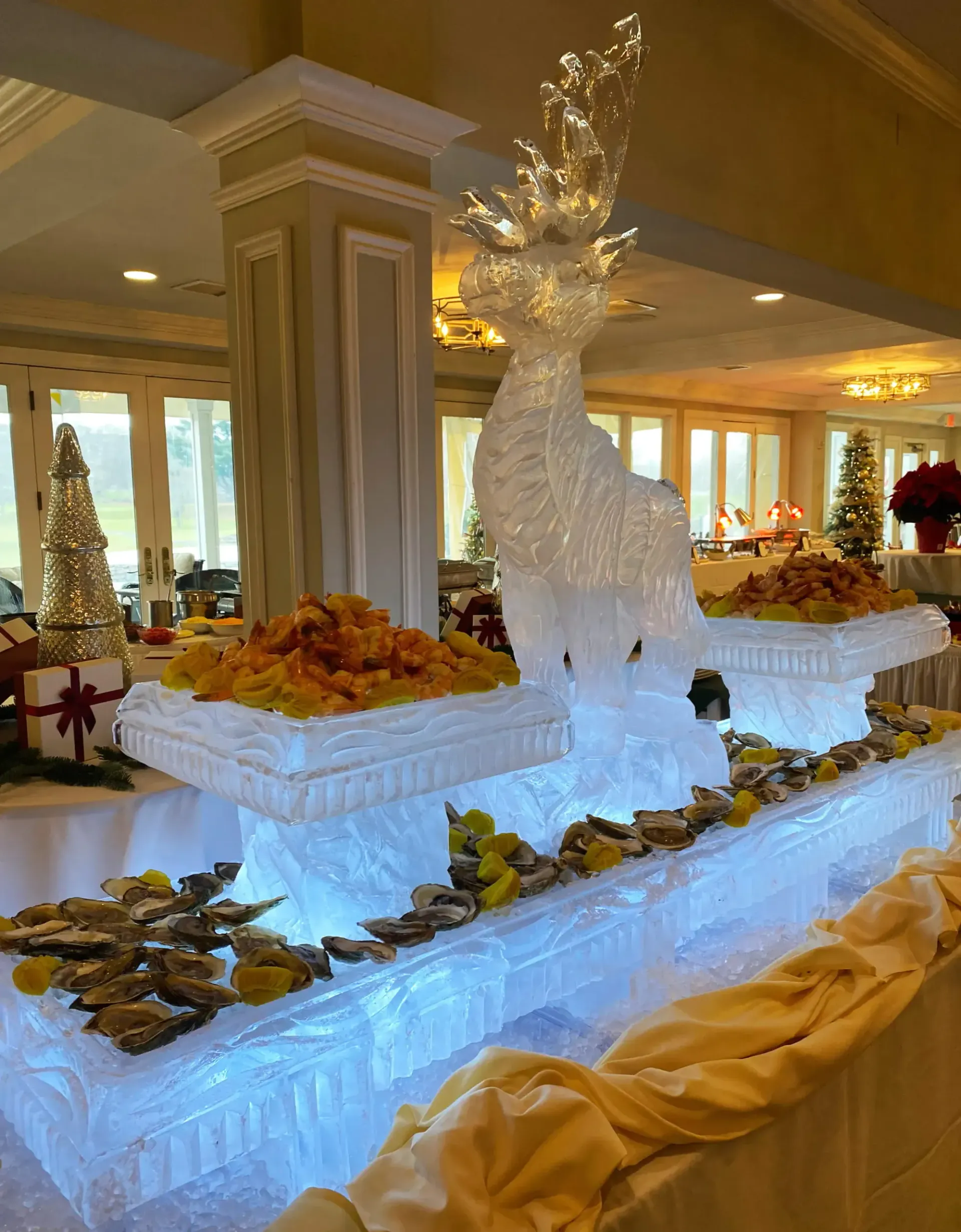Elegant dessert buffet with a white ice sculpture centerpiece and assorted pastries on glowing trays