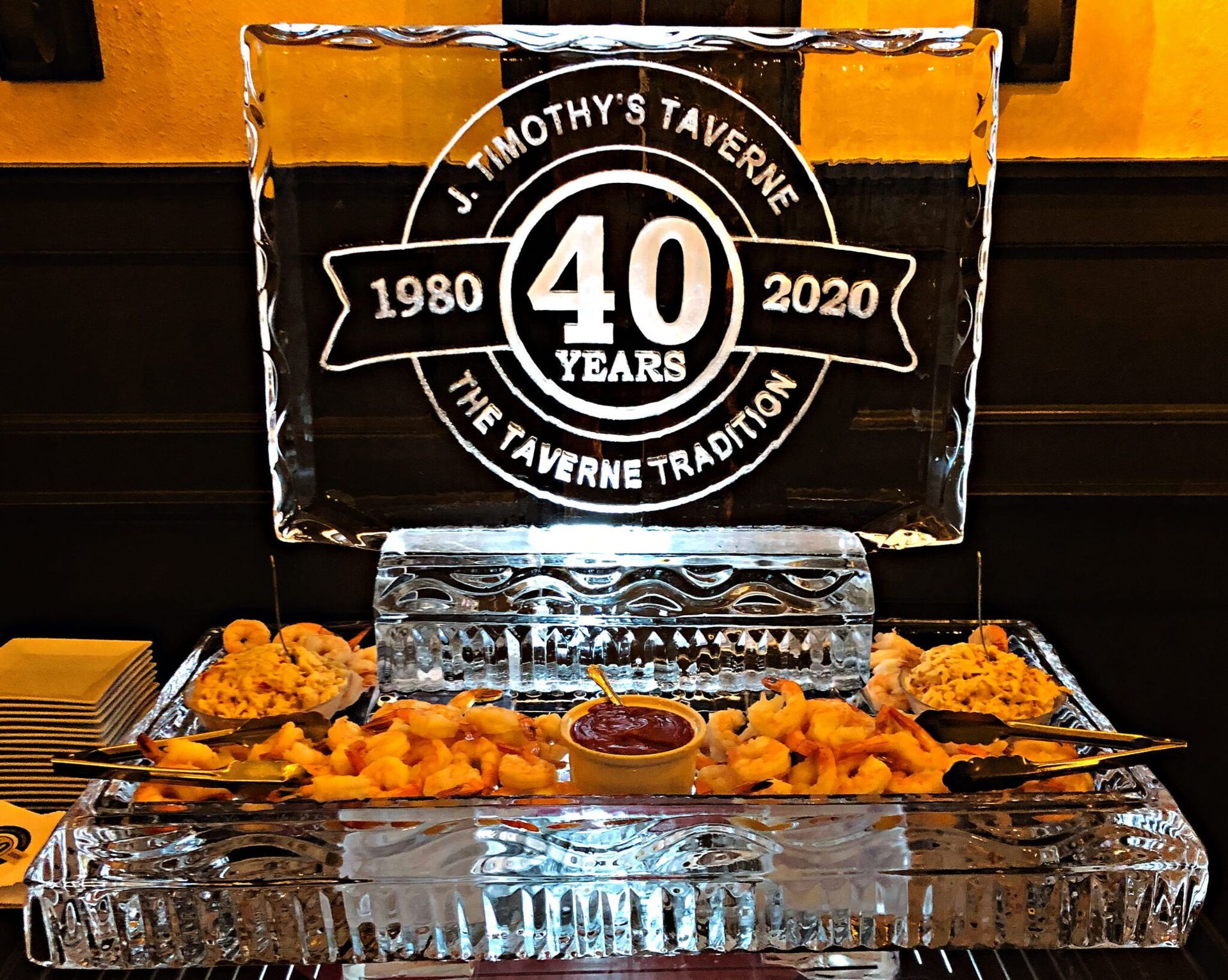40th anniversary display with black-and-white sign and trays of food in a buffet setting
