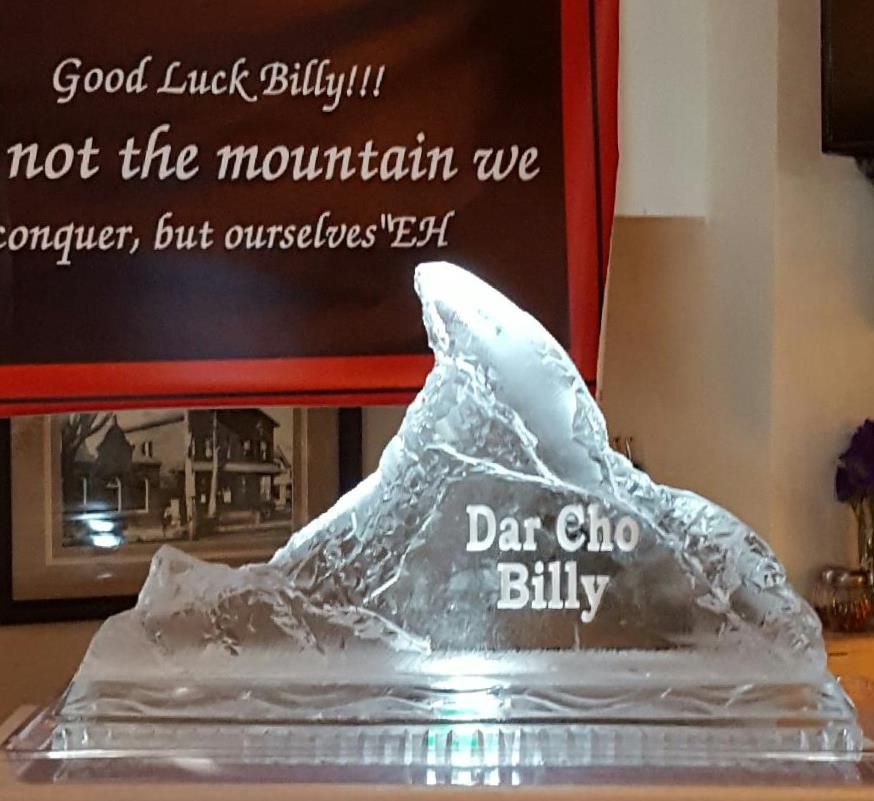 Ice sculpture on a table with “Dar Cho Billy” text, in front of a banner reading “Good Luck Billy!!!”