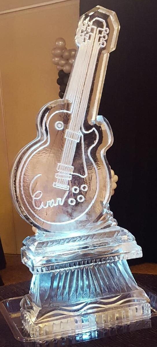 Clear glass guitar-shaped award on a faceted crystal base