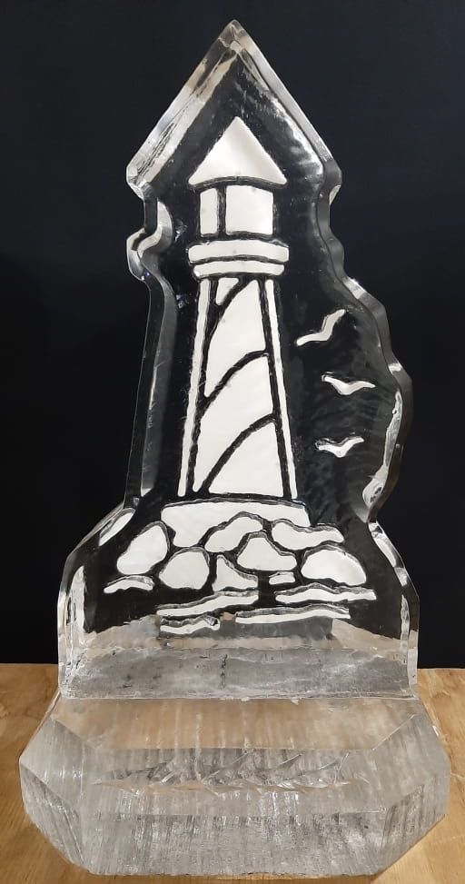 Clear acrylic plaque engraved with a lighthouse and rocks on a wooden base