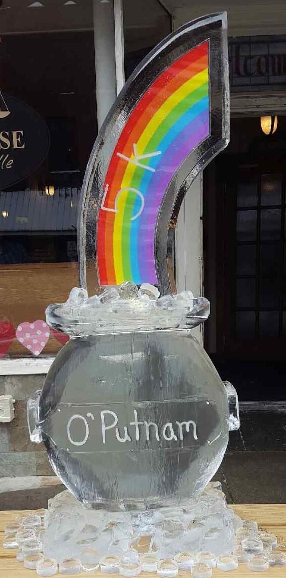 Rainbow decoration labeled “O’Rhan” displayed in a clear jar on a table, with ice-like crystals around it