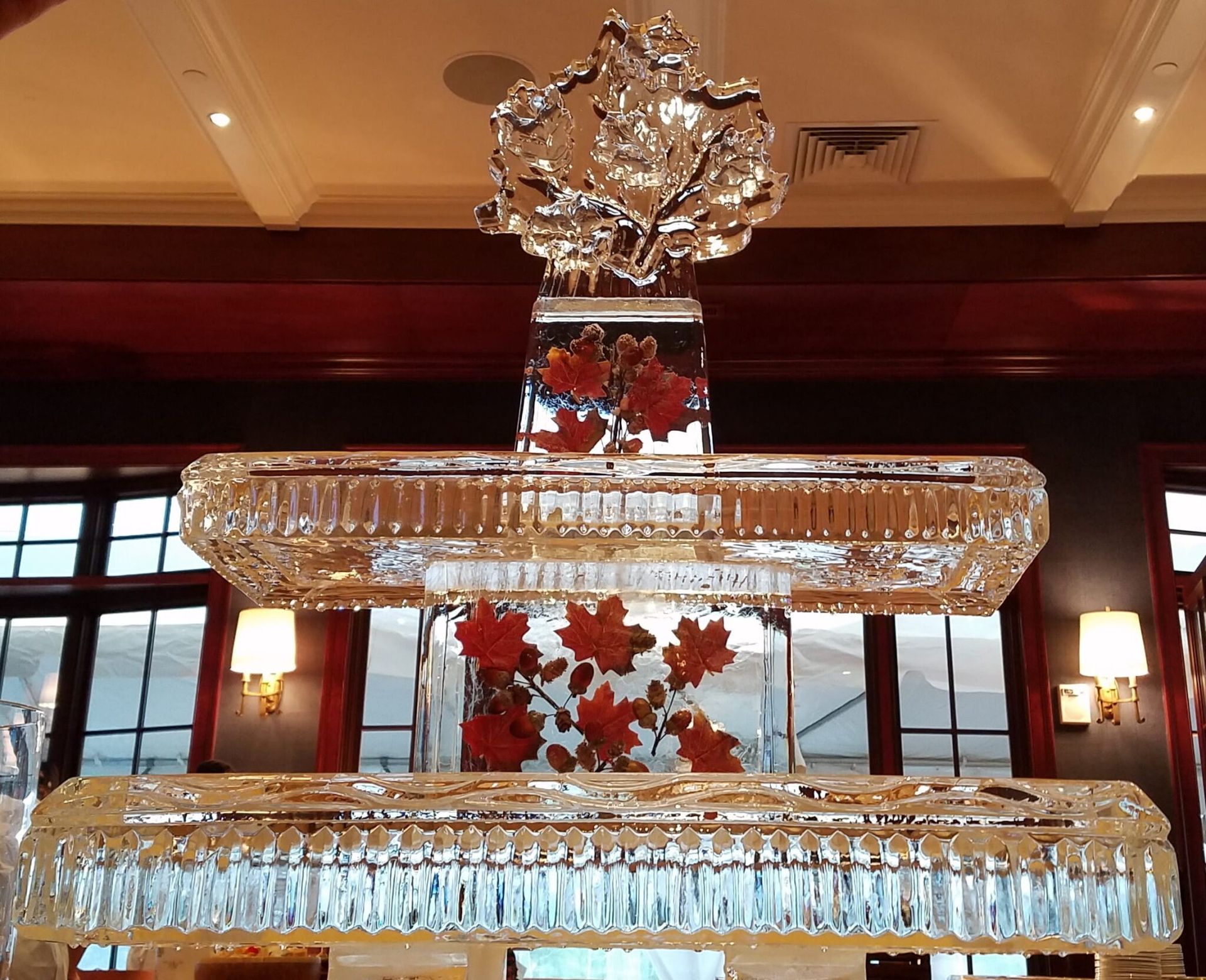 Crystal chandelier with red floral accents hanging in a warmly lit room