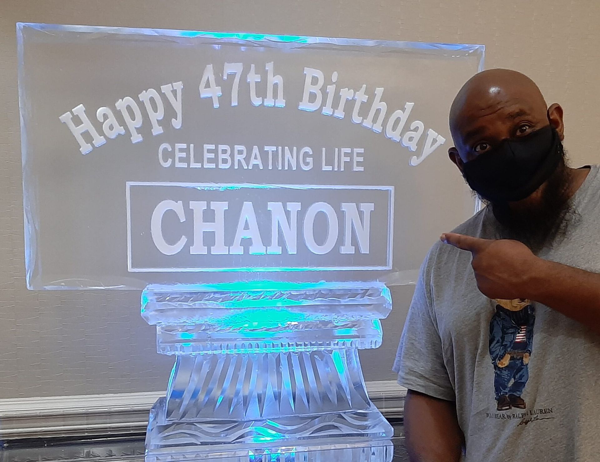 Man standing beside illuminated birthday sign reading “Happy 47th Birthday Celebrating Life Chanon”