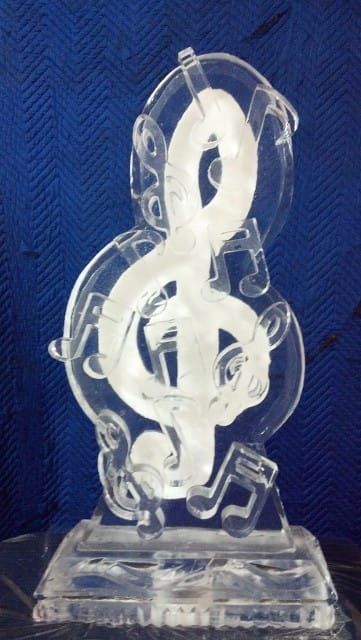 Clear acrylic treble clef trophy on a blue textured background