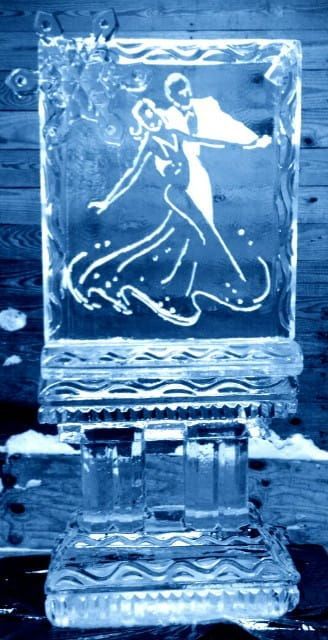 Blue-tinted ice sculpture of a dancing figure on a pedestal