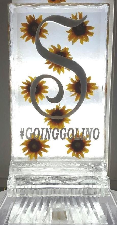 Glass block with sunflowers around a large “S” and the text “#GOINGGOLDNO” etched below.
