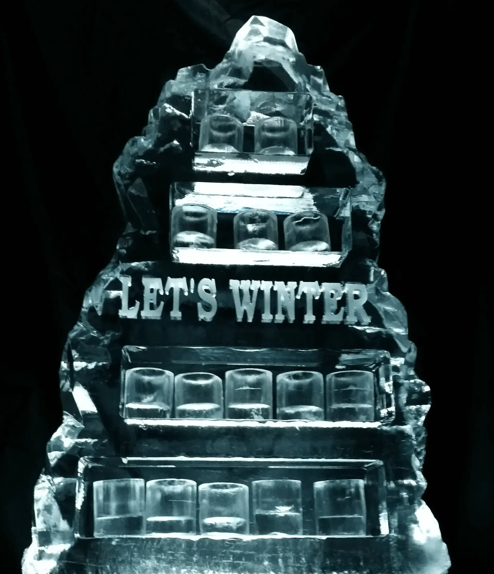 Ice sculpture with stacked buildings and the words “LET’S WHITE” carved into it.