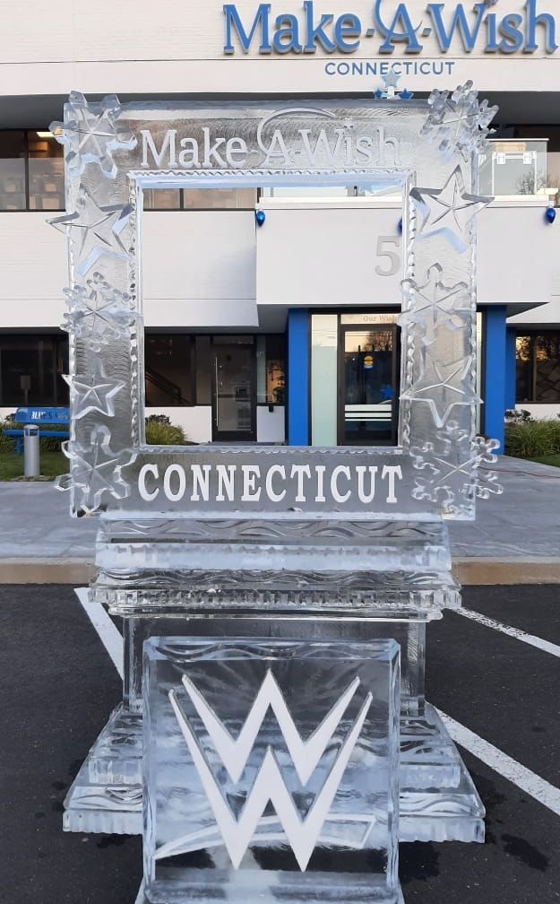 Make-A-Wish Connecticut silver display with a large “W” on a platform outside a building