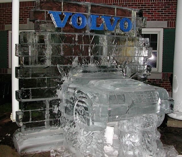 Ice-covered Volvo car display with large blue VOLVO sign on top
