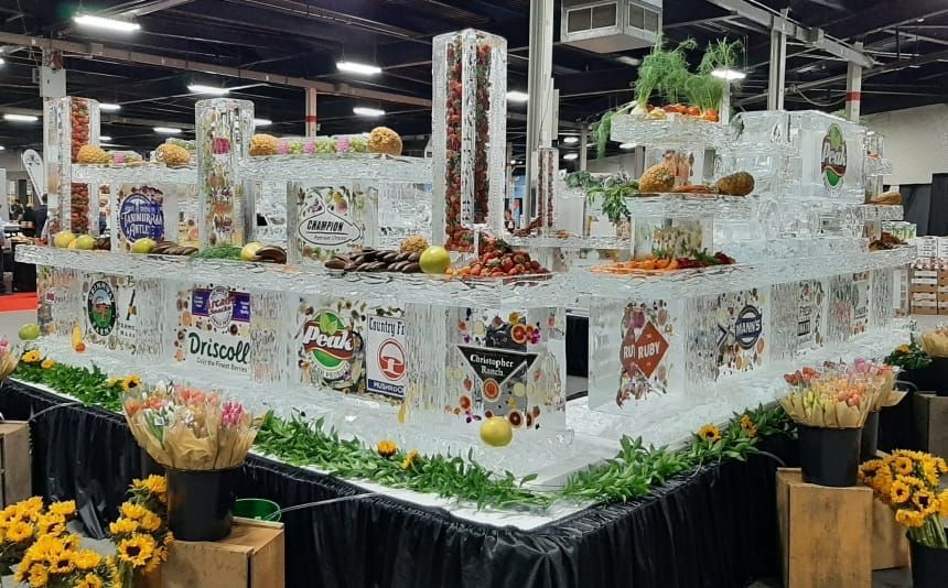 Decorative white float covered in flowers and gift baskets at an indoor event display