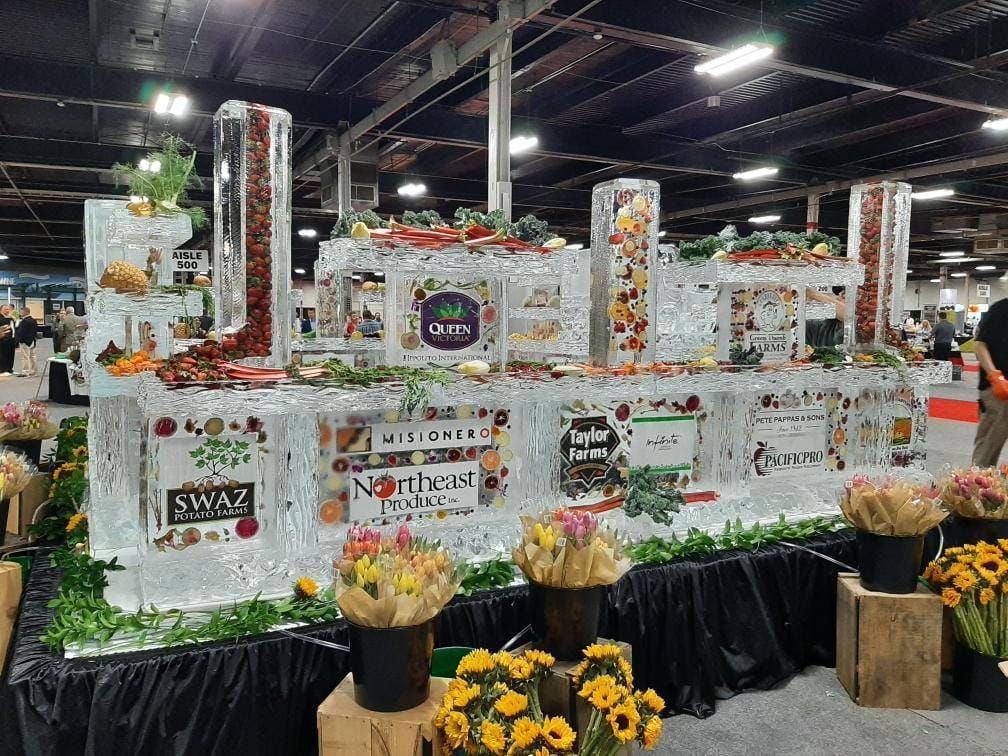 Decorated floral float with assorted product signs at an indoor event center
