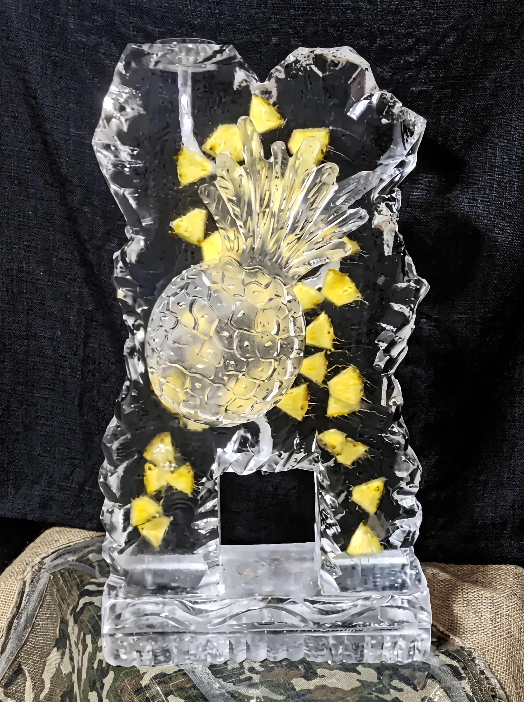 Clear crystal trophy with a yellow sunburst design on a dark background
