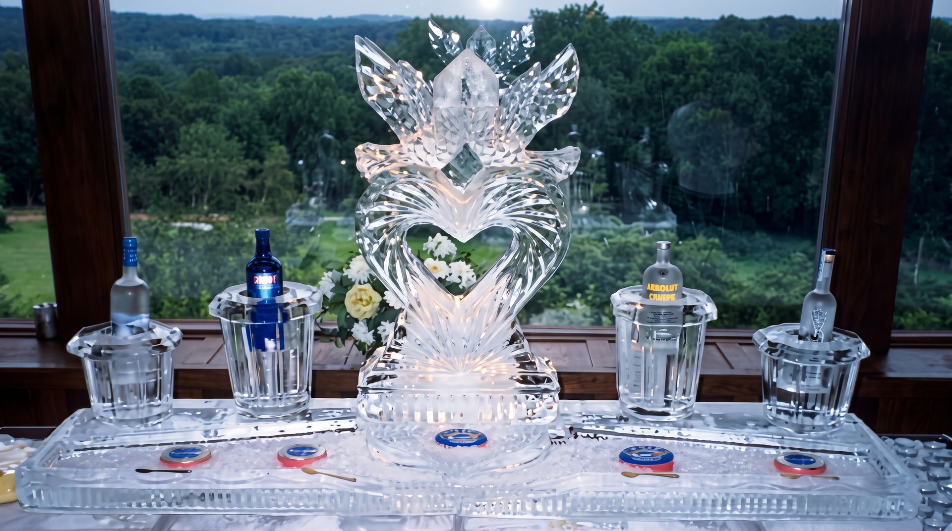 Crystal ice sculpture centerpiece on a table with glass decanters, overlooking a wooded landscape