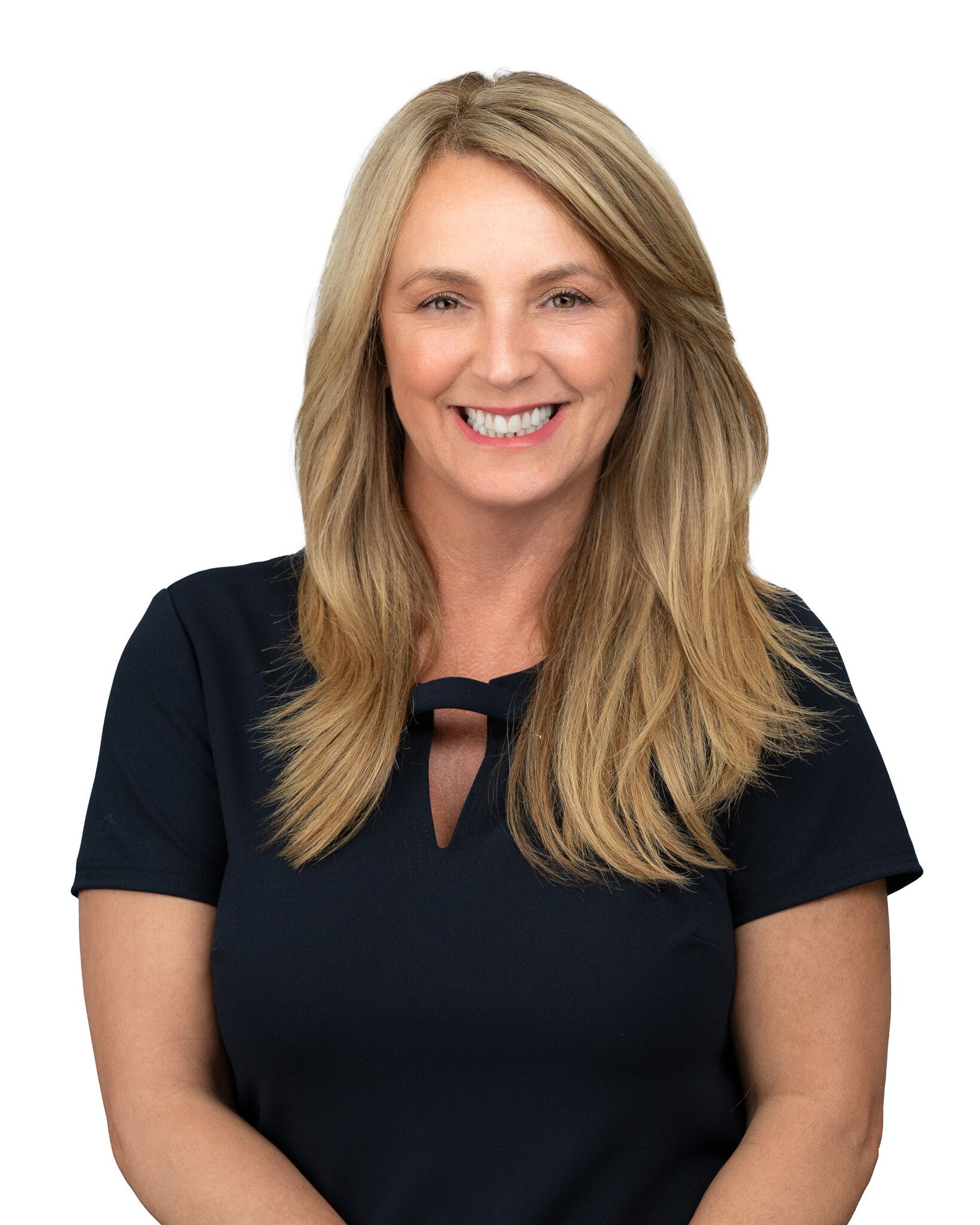 Woman with blonde hair wearing a dark blue top, smiling at the camera.