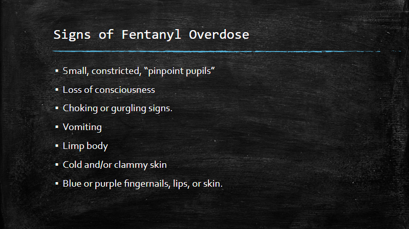 Blackboard sign listing signs of fentanyl overdose in white chalk text