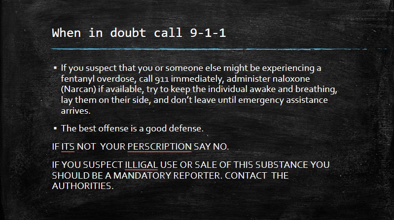 Black sign with white text urging to call 9-1-1 for emergencies or suspected substance use