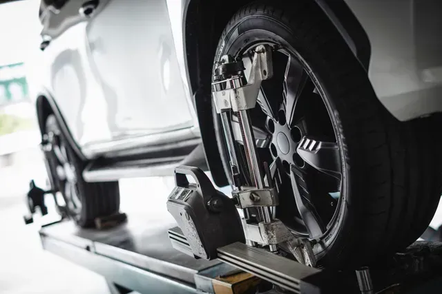 Car wheel aligned on a computerized wheel balancer in an auto repair shop