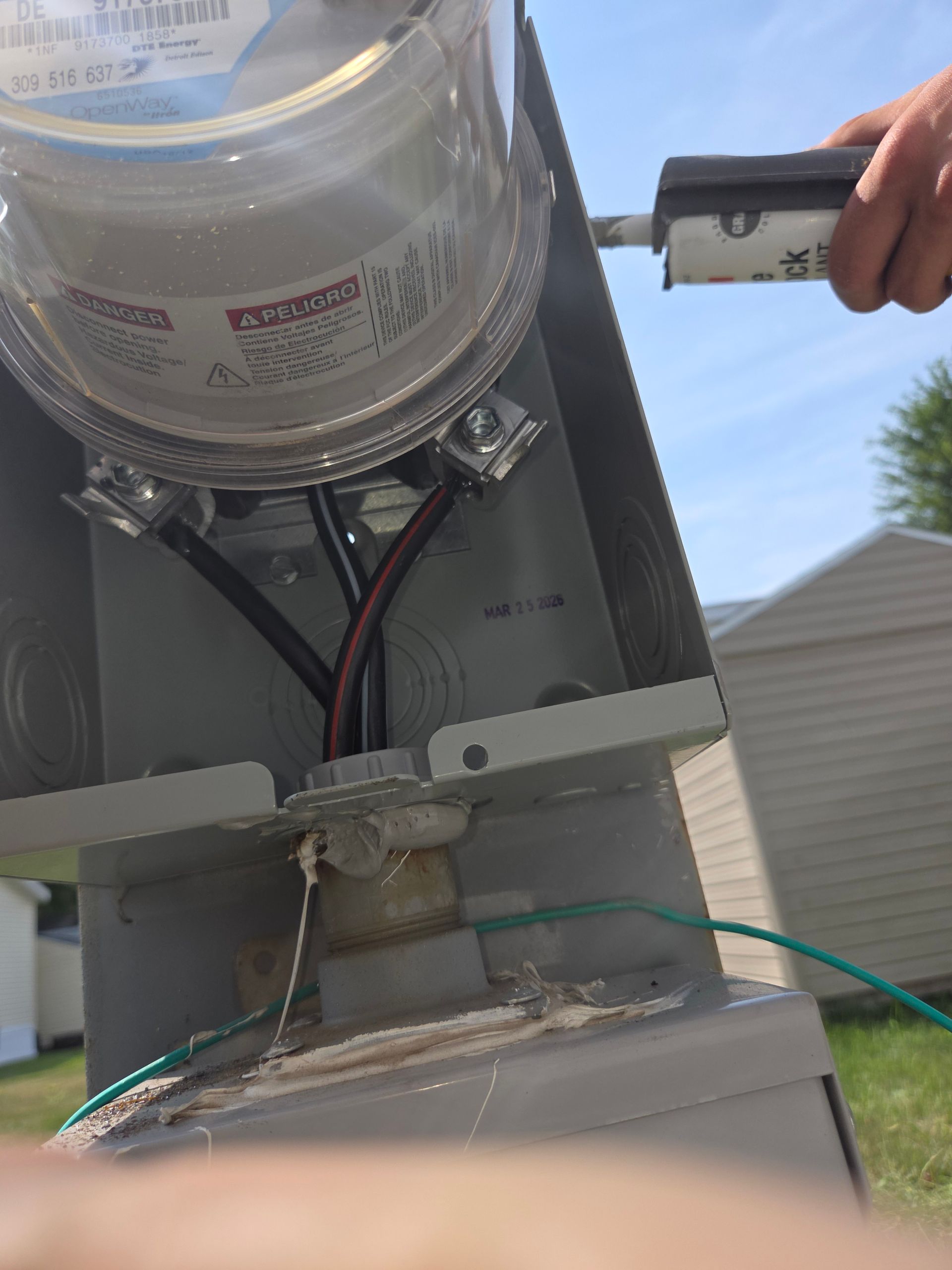 Close-up of an electrical meter and wiring mounted on a metal pole outdoors