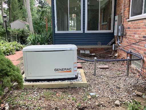 Generac backup generator beside a brick house in a gravel yard