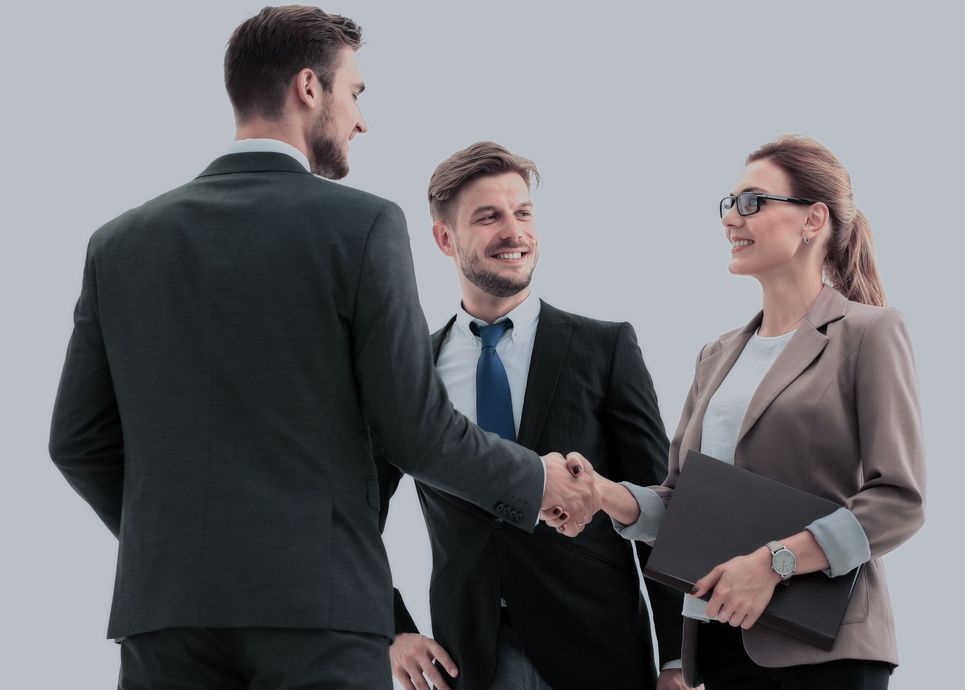Three professionals in business attire shaking hands in a studio setting