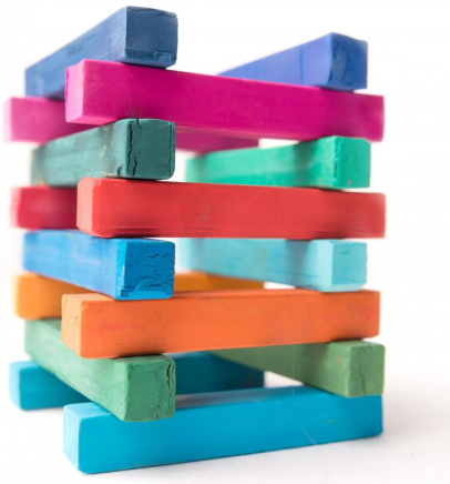 Stack of colorful wooden blocks arranged in a wobbly tower