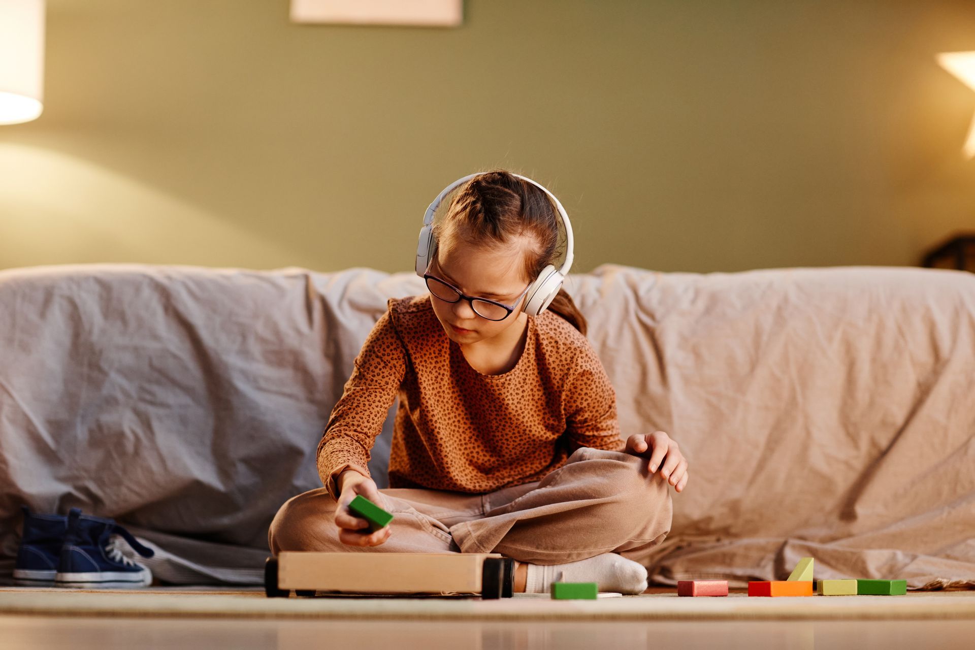 Child coloring on the floor beside a couch in a cozy living room