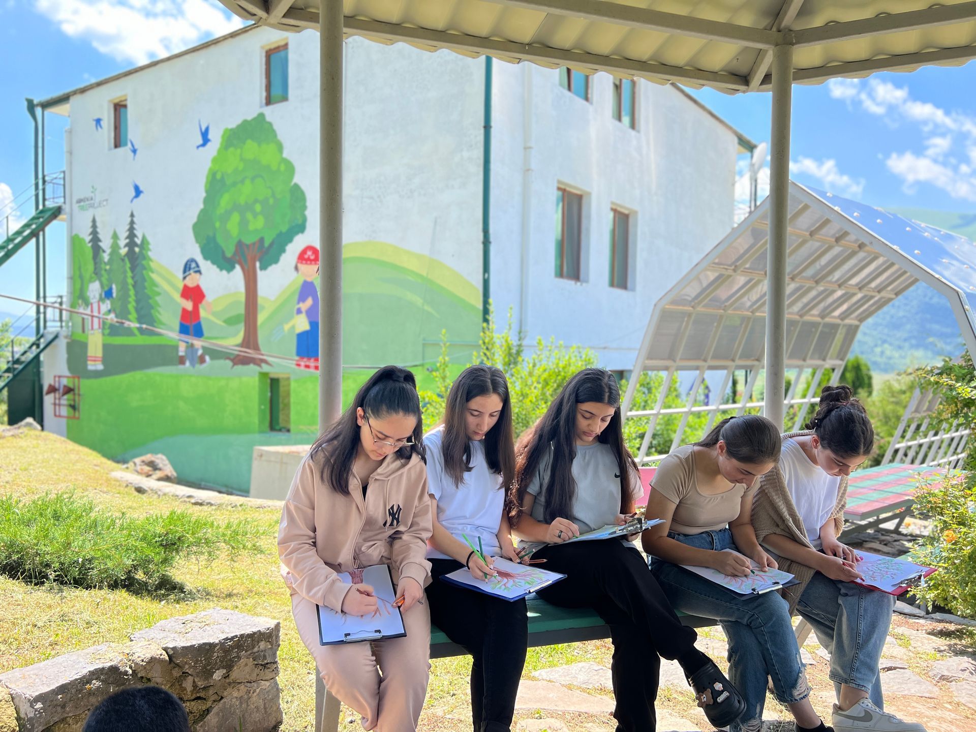  ATP Eco Club students at the Ohanian Center in Margahovit express their creativity by drawing trees in an outdoor classroom, blending imagination with environmental learning.