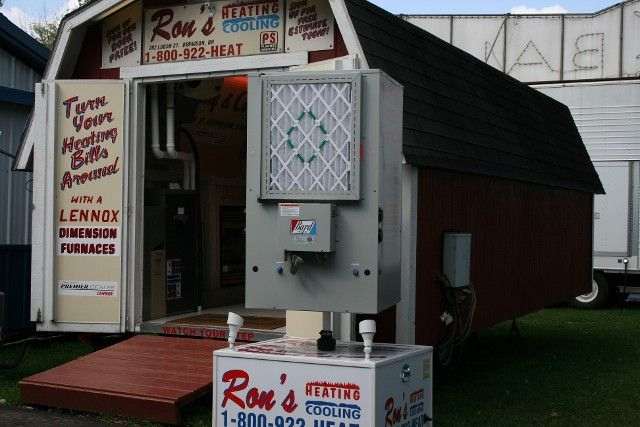 Ron's Heating & Cooling display: Red barn with Lennox furnace, open door, white sign, and phone number.