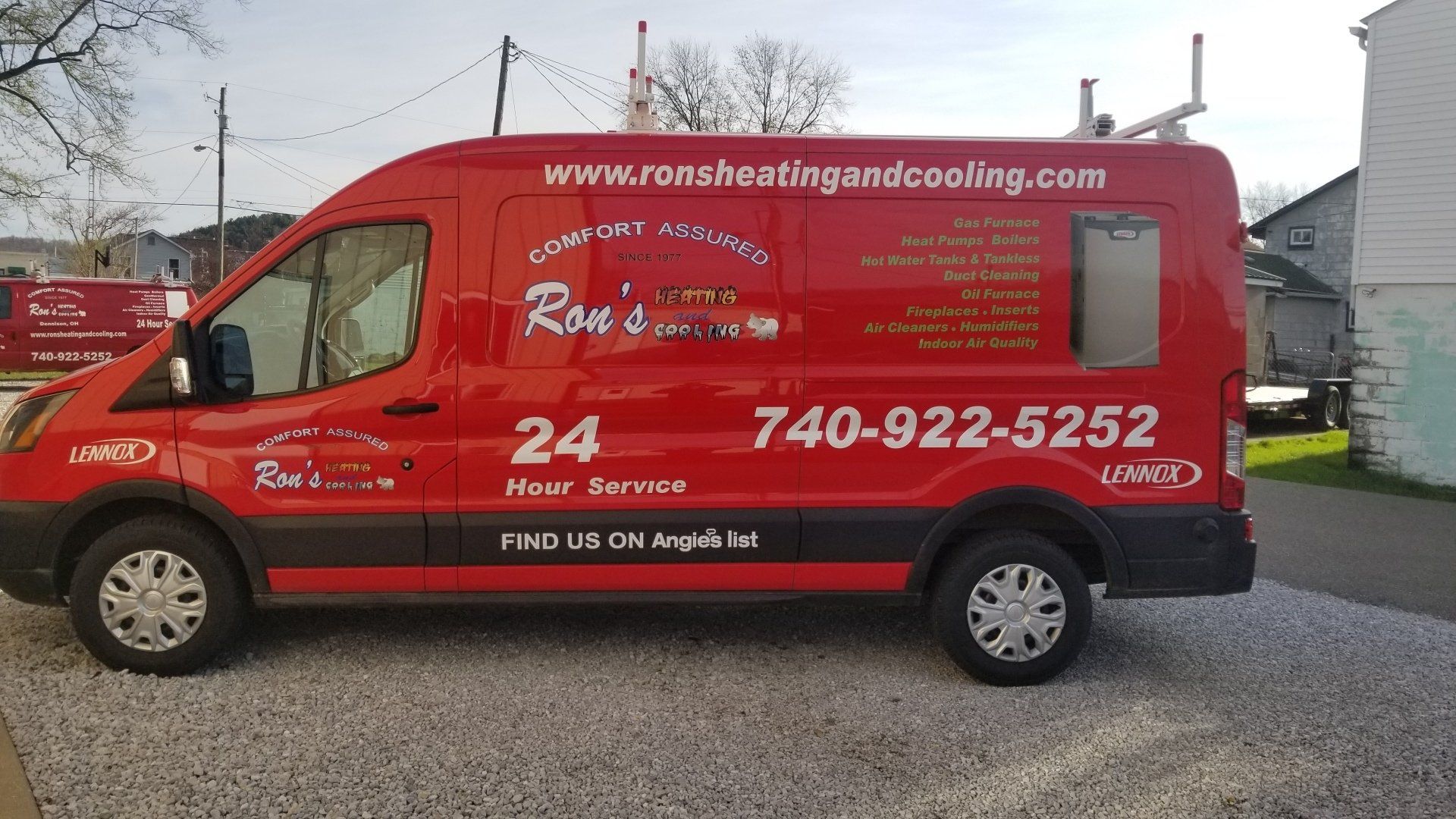 Red service van for Ron's Heating and Cooling with contact info and website parked on gravel.