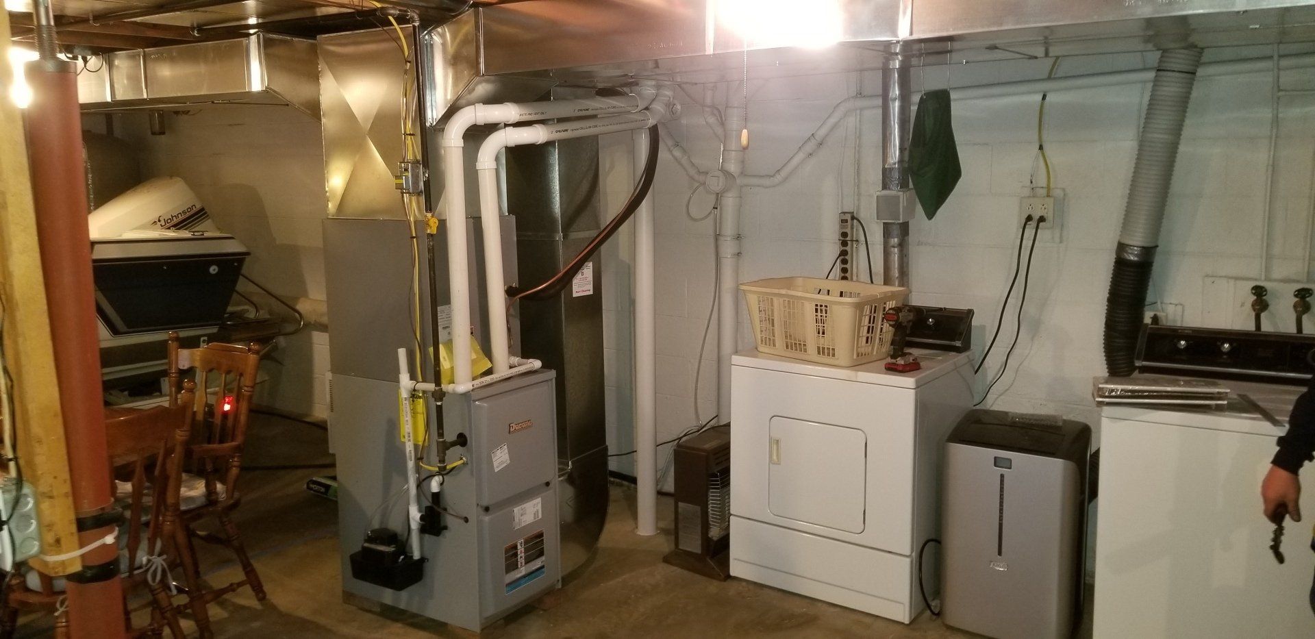 Basement interior with furnace, laundry machines, and exposed ductwork.
