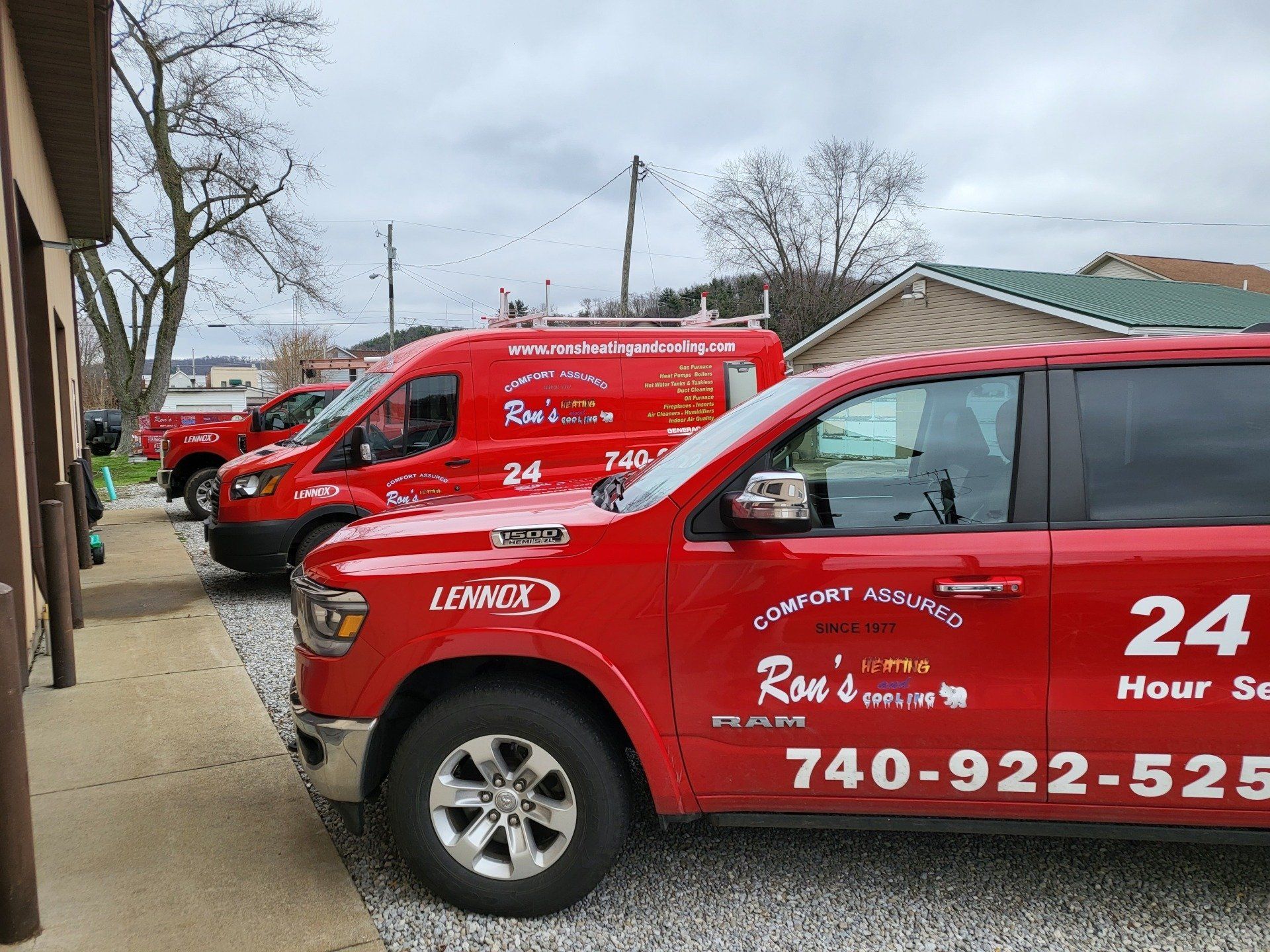Red service vans parked outside a building with the company name, Ron's, and phone number 740-922-5256.