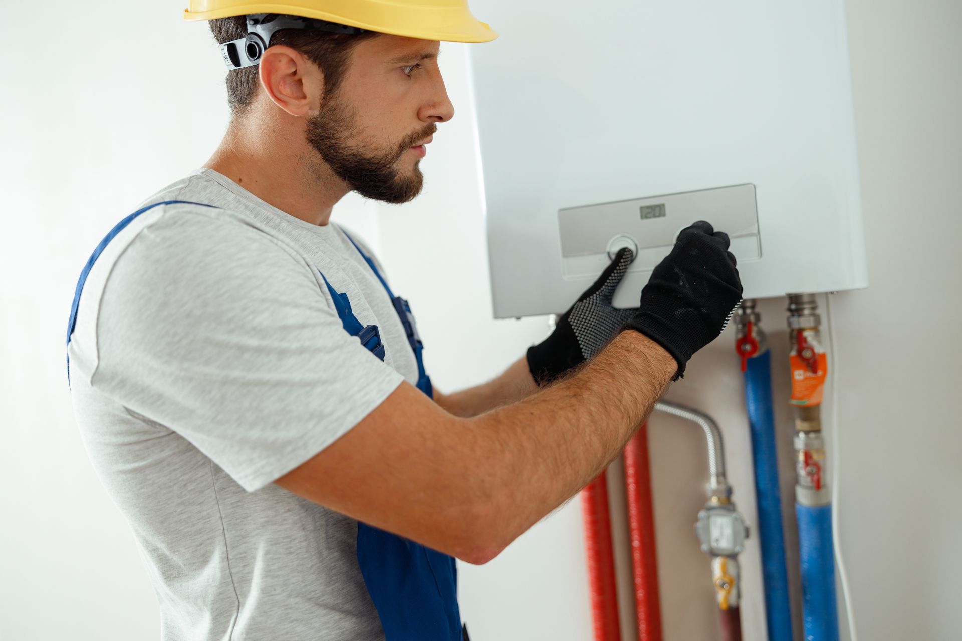 Water heater technician adjusting a residential boiler or hot water system