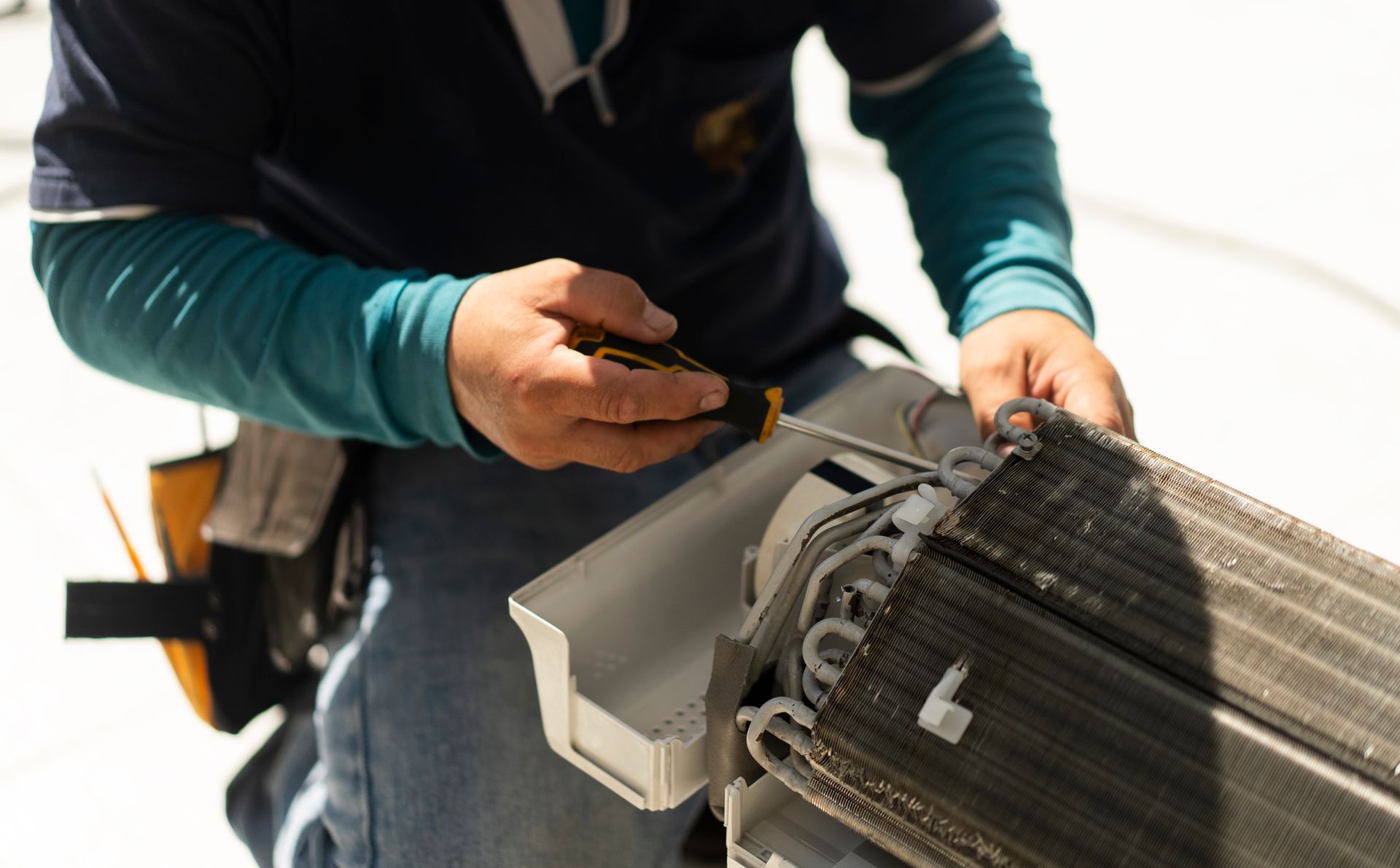 A man is repairing an AC.