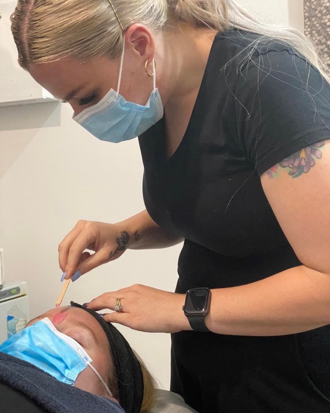 A Woman Wearing a Mask is Waxing a Person's Eyebrows — Glam Hair and Beauty in Woy Woy, NSW