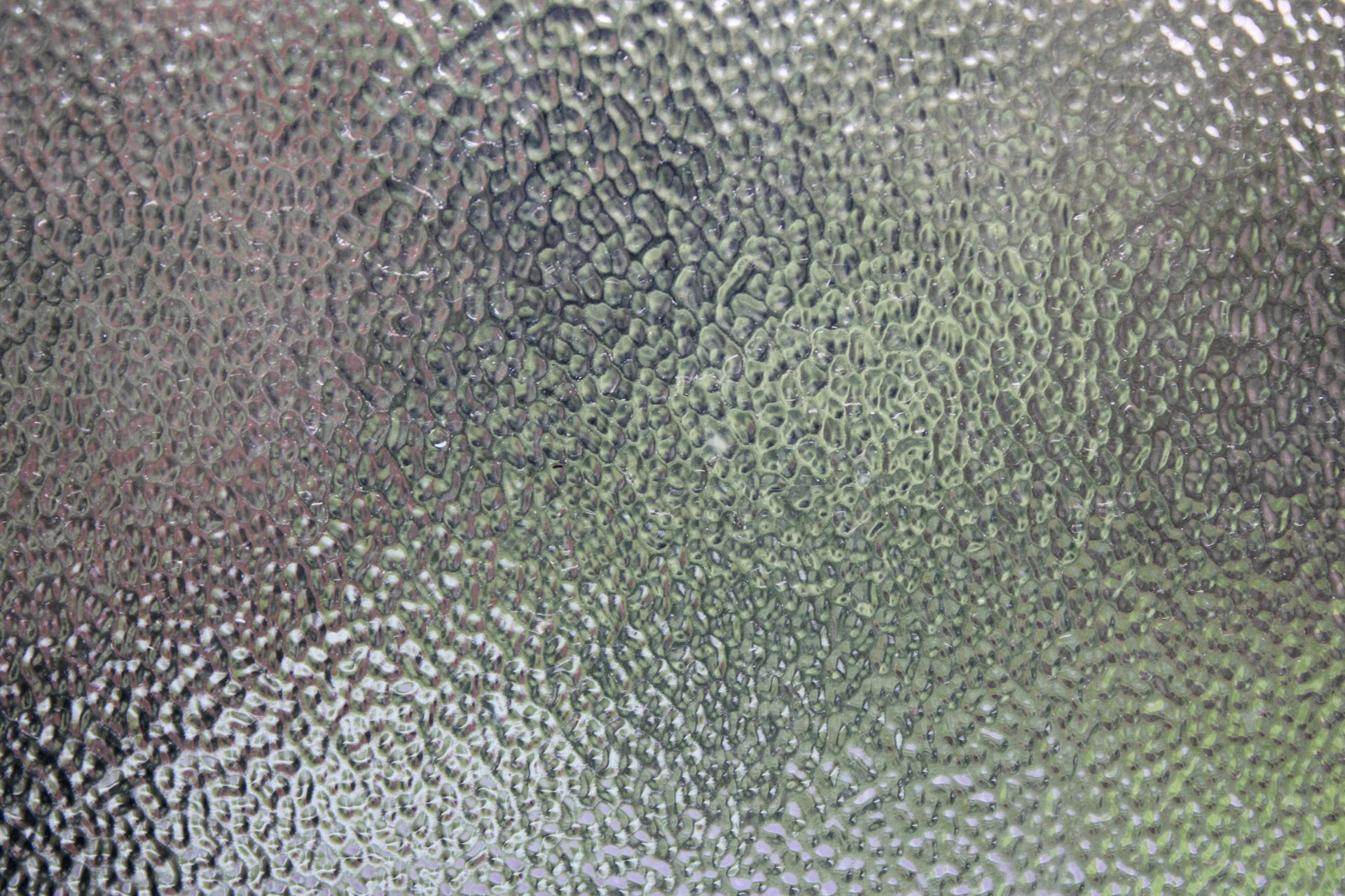 Textured frosted glass surface with gray and greenish tones